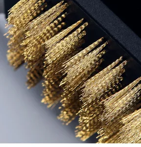 Vista dettagliata delle resistenti setole in ottone dorato di una spazzola per pulizia BBQ