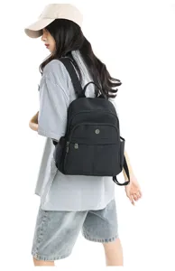 Detailansicht des schwarzen Nylon-Rucksacks mit Fronttaschen und Metall-Reißverschluss