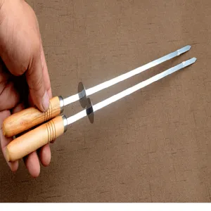 Zwei Grillspieße aus Edelstahl mit ergonomischen Holzgriffen in der Hand