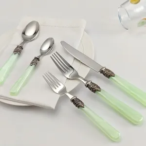 Vintage-Besteckset mit eleganten hellgrünen Griffen und kunstvollen Metallakzenten