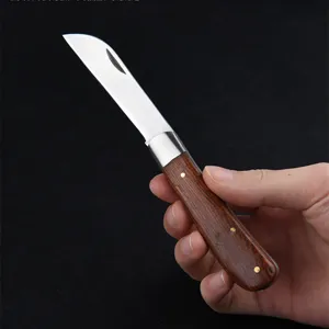 Close-up of a portable wooden handle folding mushroom knife for outdoor gardening