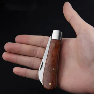 Compact folding gardening knife with a classic wooden handle shown held in hand