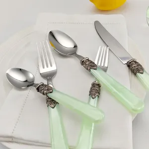 Nahaufnahme von Vintage Besteckset mit grünen Acrylgriffen und verzierten Details