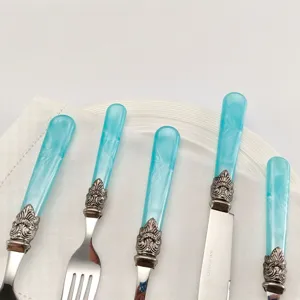 Close-up van blauwe vintage acryl handgrepen op een luxe bestekset van roestvrij staal