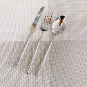 Vue détaillée d'un ensemble de couverts en inox 304 avec motifs diamantés sur le manche