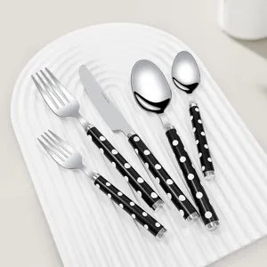Moderne 5-delige roestvrijstalen bestekset met zwart-witte gestippelde handgrepen op dienblad
