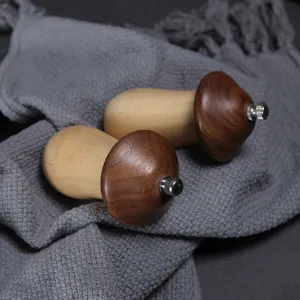 Premium mushroom-shaped wooden manual pepper grinders set displayed on grey fabric.