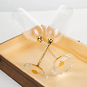 Elegant crystal champagne flute set featuring gold leaf stems in a luxury wooden gift box
