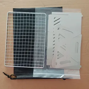 Portable foldable stainless steel BBQ grill set with mesh grate and storage bag for camping.