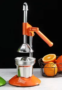 Detailed view of an orange manual lever-type fruit juicer on a marble surface
