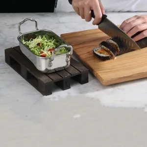 Detalle de una bandeja de madera carbonizada negra utilizada para emplatar alimentos