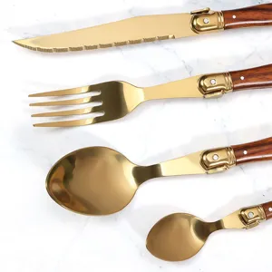 Elegante set di posate lusso oro in acciaio inox con manici venatura legno su marmo