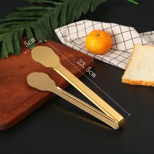 Close-up view of large golden stainless steel food tongs with 23.5cm dimension markings