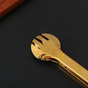 Close-up detail of high-quality gold stainless steel food tongs with a unique spork head design