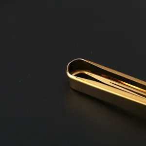 Macro view of the smooth golden hinge and polished stainless steel finish on food tongs