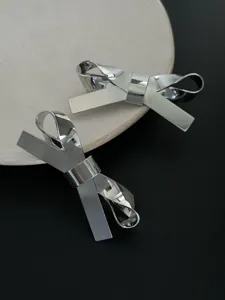 Nahaufnahme von minimalistischen silbernen 3D-Schleifen-Haarspangen mit Polierung