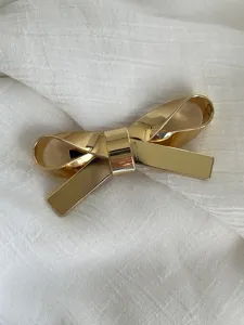 Minimalistische goldene Haarklammer und Brosche in Schleifenform mit Glanz-Finish.