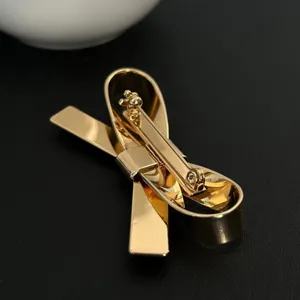 Hochwertige minimalistische goldene 3D-Schleifenbrosche und Haarklammer mit Spiegelglanz-Finish