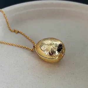 Detaillierte Makroansicht der Gravuren an einer Vintage-Halskette mit goldenem Ei-Anhänger