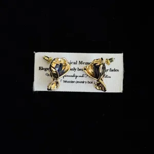 Λεπτομερής λήψη χρυσών σκουλαρικιών μπουκέτο vintage με σκούρους μπλε πολύτιμους λίθους.