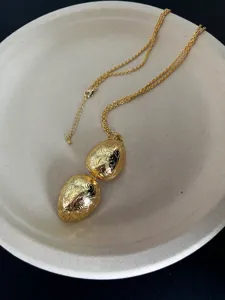 Detaillierte Nahaufnahme goldener Vintage-Anhänger mit sehr feiner floraler Gravur