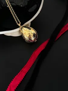 Detaillierte Makroansicht eines goldenen Vintage-Eieranhängers mit kunstvoller Reliefgravur