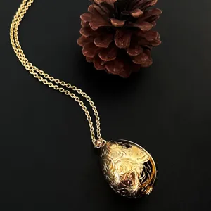 Elegante goldene Halskette mit eiförmigem Anhänger und aufwendigen Blumen gravuren