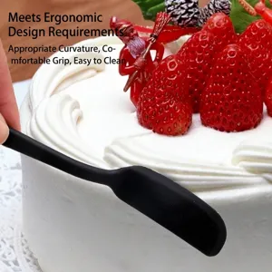 Spatola ergonomica in silicone nero utilizzata su una torta alle fragole