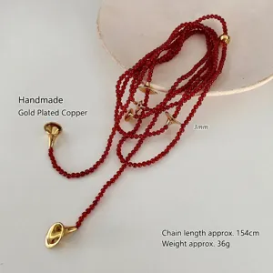 Macro detail of French vintage red agate beaded necklace with golden trumpet elements