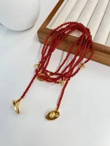Macro detail of French vintage red agate bead necklace with gold trumpet pendants
