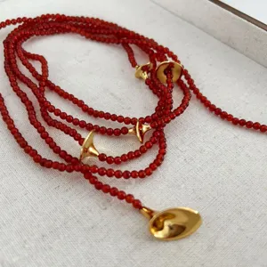 French vintage long red agate beaded necklace with elegant gold trumpet accents for women.