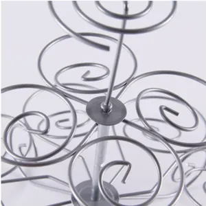Detailaufnahme der Makro-Textur an einem silbernen spiralförmigen Cupcake-Ständer aus Metall