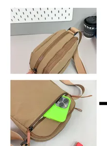 Detail der braunen Nylon-Umhängetasche mit Doppelreißverschluss und Handytaschenkapazität