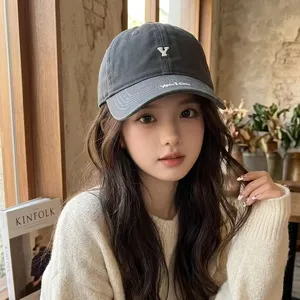 Close-up detail of dark gray cotton baseball cap with embroidered letter Y and stylish brim text.