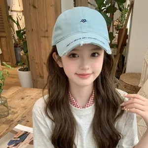 Close-up of a girl wearing a light blue retro baseball cap with heart embroidery