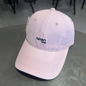 Vista dettagliata del cappellino da baseball rosa lavato con ricamo blu open MIND sul davanti