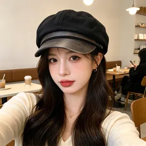 Stylish black newsboy hat with PU leather brim worn by a model in a cafe setting