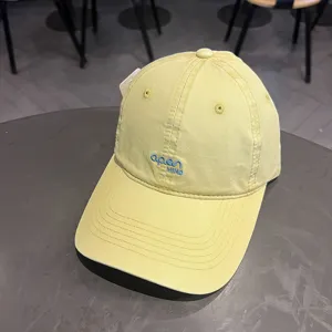 Primo piano di un cappellino da baseball in cotone giallo con ricamo blu 'open MIND'
