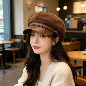 Stylish brown PU leather baker boy hat for women shown on a model in a cozy cafe