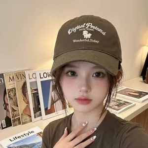 Close-up of a brown cotton baseball cap featuring cute sheep embroidery and text detail.