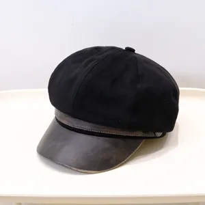 Macro view of a vintage black newsboy hat featuring a weathered brown PU leather brim
