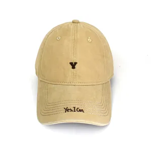 Close-up detail of a classic beige baseball cap featuring brown embroidered letter and phrase.