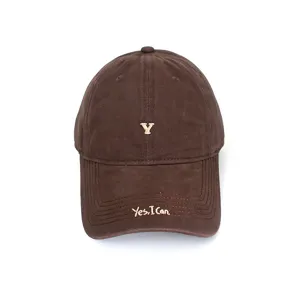 Close-up of the brown baseball cap featuring delicate embroidered letter Y and brim text.