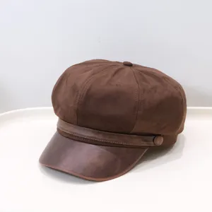 Detailed view of a vintage brown newsboy hat showing the textured suede and leather brim.