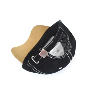 Detail of a black baseball cap with white contrast stitching and an adjustable metal buckle.