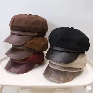 Vintage newsboy hats in multiple colors stacked on a minimalist white tray