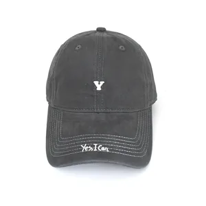 Dark grey cotton baseball cap with white embroidered Y logo and Yes I Can brim text detail.