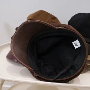Detail of retro PU leather newsboy cap showing black lining and adjustable strap