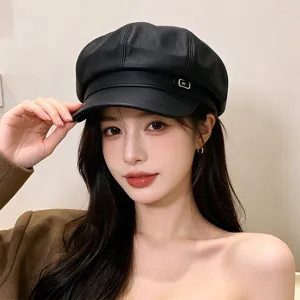 Detailed view of a stylish black PU leather newsboy hat featuring a small metal logo buckle