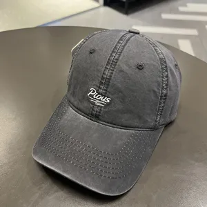 Dettaglio del cappello da baseball grigio lavato con ricamo bianco 'Pious'